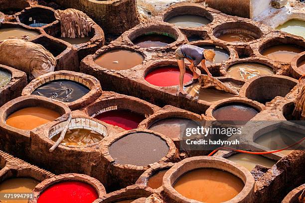 man working in the tannery, fez, morocco - tannery stock pictures, royalty-free photos & images
