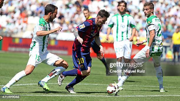 Lionel Messi of FC Barcelona competes for the ball with Deivid and Pantic of Cordoba CF during the La Liga match between Cordoba CF and FC Barcelona...