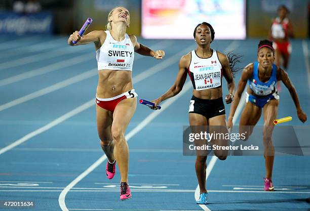 Justyna Swiety of Poland and Audrey Jean-Baptiste of Canada cross the finish during round one of the womens 4 x 400 metres relay on day one of the...