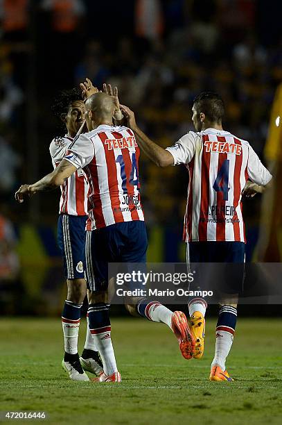 Jorge Enriquez of Chivas celebrates with teammates after scoring his team's first goal during a match between Tigres UANL and Chivas as part of 16th...