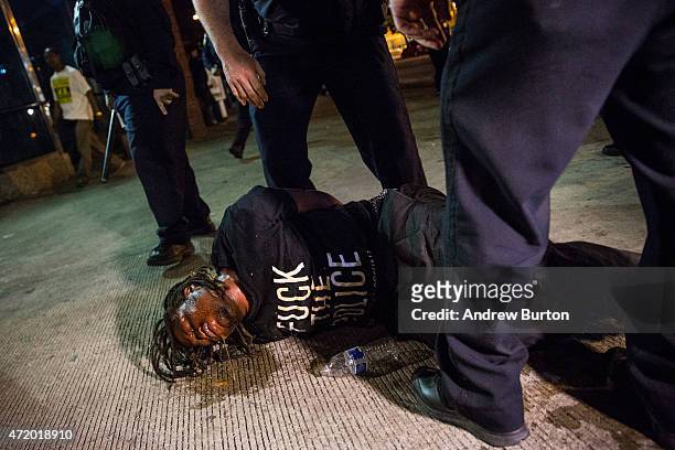 Man is detained after being pepper sprayed in the face by police at the end of a day of protests in the Sandtown neighborhood where Freddie Gray was...