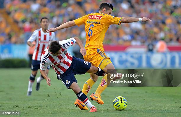 Isaac Brizuela of Chivas vies for the ball with Jorge Torres of Tigres during a match between Tigres UANL and Chivas as part of 16th round of...