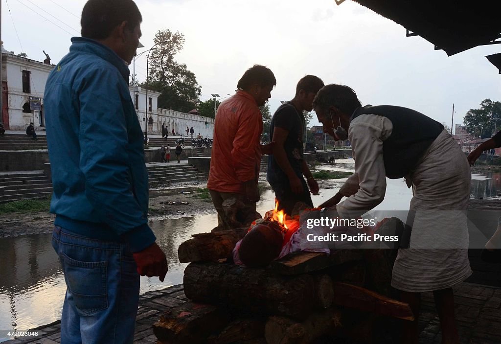 Survivors gathered to mourn and cremate relatives and...