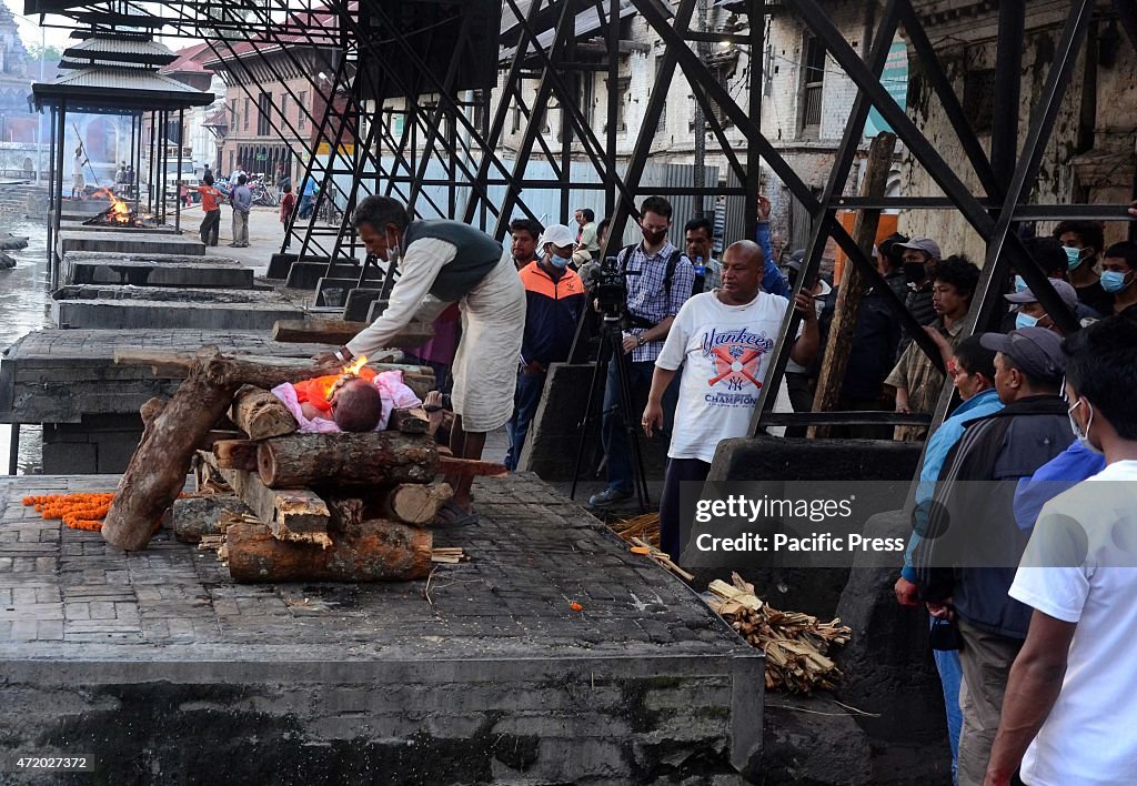 Survivors gathered to mourn and cremate relatives and...