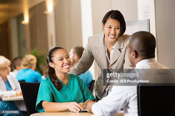 hospital administrator interviewing nurse for potential employment - nurse recruitment stock pictures, royalty-free photos & images