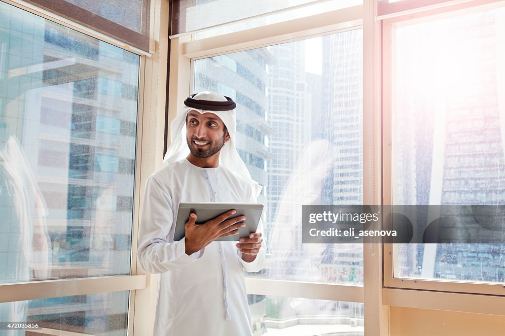 Arabischer Geschäftsmann mit digitalen tablet in Dubai Büro.