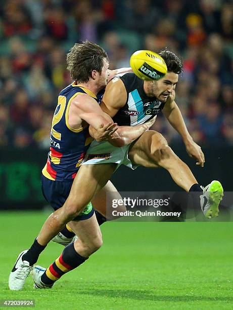 Chad Wingard of the Power kicks whilst being tackled by Patrick Dangerfield of the Crows during the round five AFL match between the Adelaide Crows...