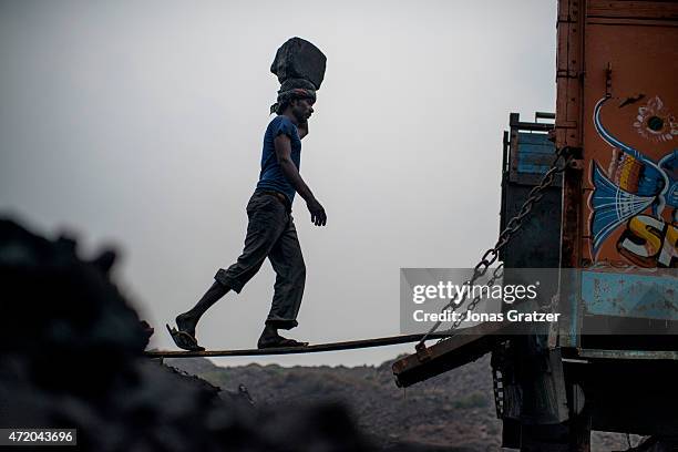 Workers in Jharia are loading a truck with coal using baskets that they carry on top of their heads. Jharia in India's eastern Jharkand state is...
