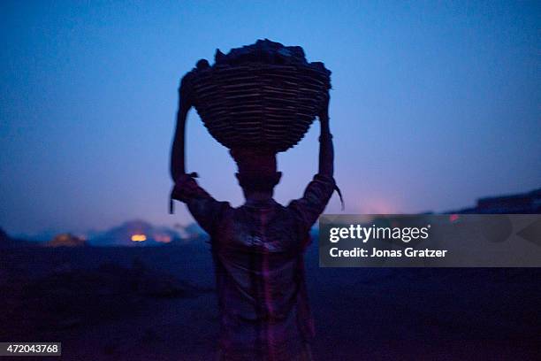 Workers in Jharia are loading a truck with coal using baskets that they carry on top of their heads. Jharia in India's eastern Jharkand state is...