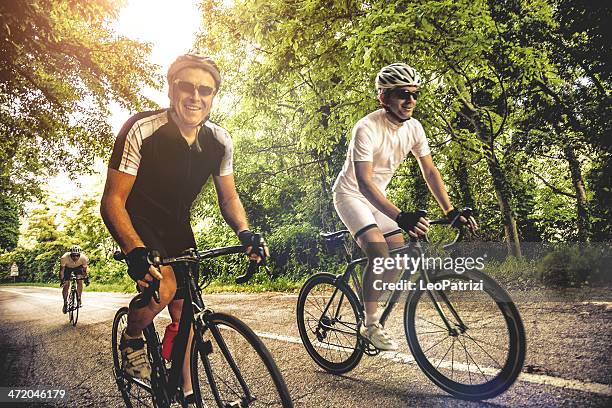 cycling on a country road - racing bicycle stock pictures, royalty-free photos & images
