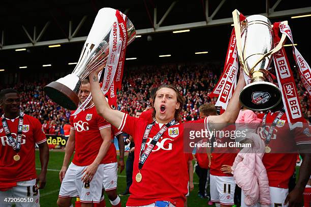 Luke Freeman of Bristol City celebrates with the League One Trophy and the Football League Trophy at the end of the Sky Bet League One match between...