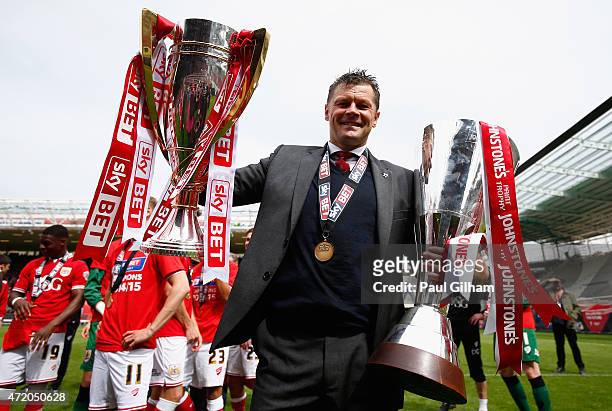 Manager Steve Cotterill of Bristol City celebrates with the League One Trophy and the Football League Trophy during the Sky Bet League One match...