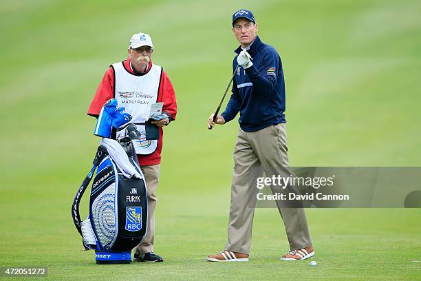 Jim Furyk stands with his caddie prior to playing his third shot on the first hole during his semi final match in the World Golf Championships...