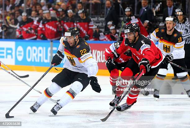 Aaron Ekblad of Canada and Matthias Plachta of Germany battle for the puck during the IIHF World Championship group A match between Canada and...