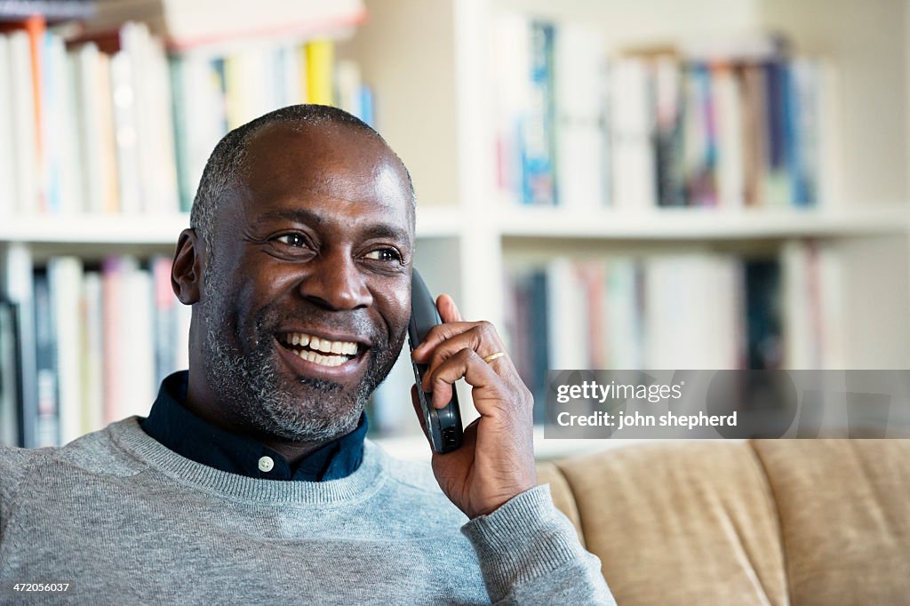 Mature Man smiling while on a telephone