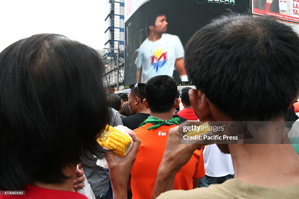 Fans eat on the middle of the street as they wait for the...