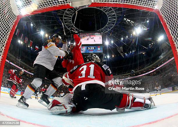 Tyler Ennis of Canada battles for position with Matthias Palchta of Germany in front of the net during the IIHF World Championship group A match...