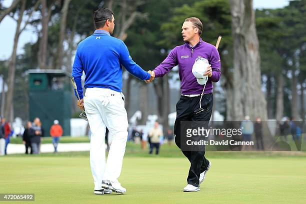 Gary Woodland shakes hands with Danny Willett of England on the 16th hole green after winning their semi final match 3&2 in the World Golf...