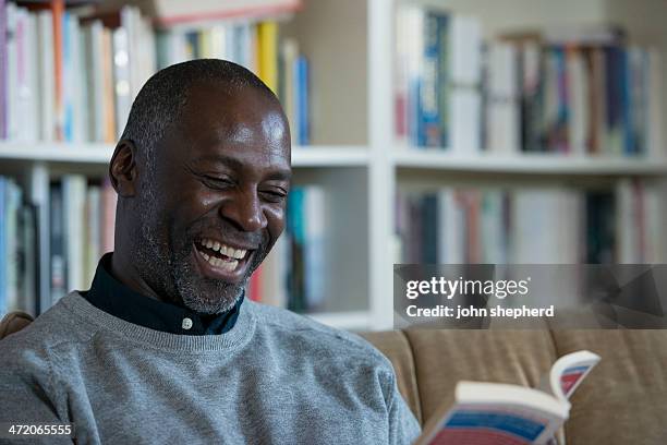 ältere männer lachen, während sie ein buch lesen. - lypseuk2013 stock-fotos und bilder