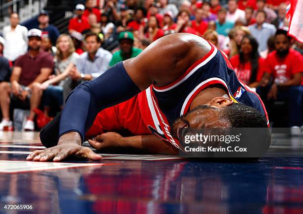 John Wall of the Washington Wizards reacts after missing a basket and landing on the floor against the Atlanta Hawks during Game One of the Eastern...