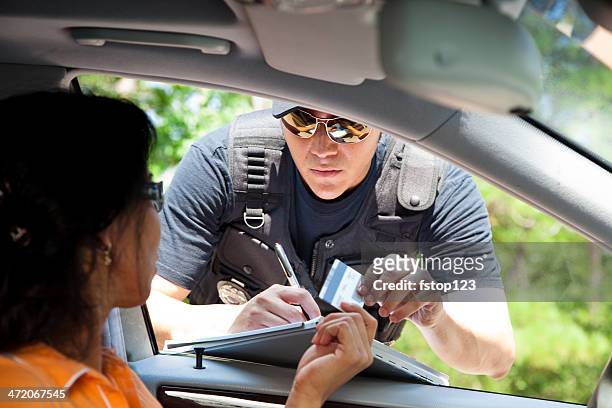 verbrechen: polizist verkehr ticket für den fahrer ein. - driving license stock-fotos und bilder