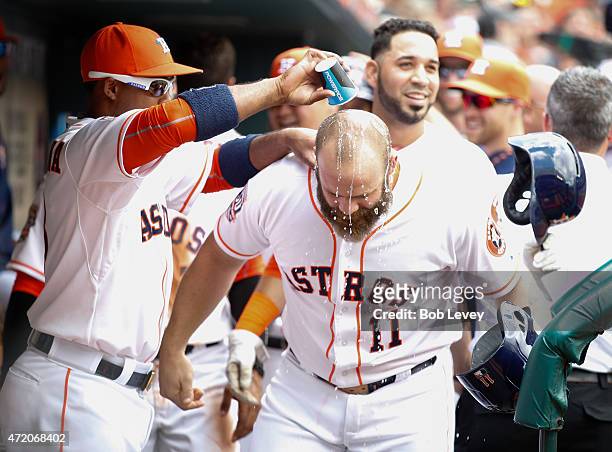 Designated hitter Evan Gattis of the Houston Astros is doused with water by Luis Valbuena after hitting a three run home run in the first inning...
