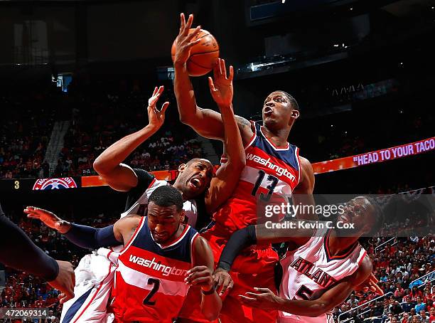 John Wall and Kevin Seraphin of the Washington Wizards defend as Al Horford of the Atlanta Hawks attempts a shot during Game One of the Eastern...