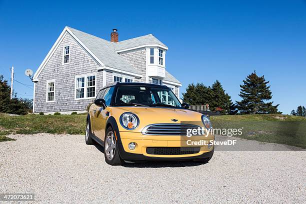 amarillo mini cooper estacionada en el frente de una cabaña junto al mar - mini cooper fotografías e imágenes de stock