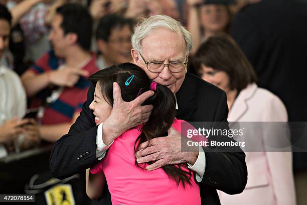 Warren Buffett, chairman of Berkshire Hathaway Inc., greets Ariel Hsing, an American table tennis player who competed in the 2012 Olympics, during a...