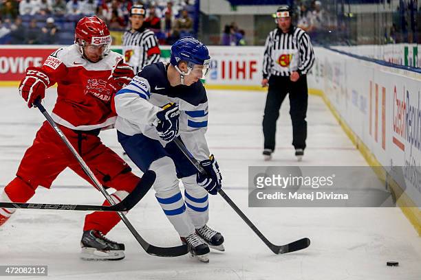 Patrick Bjorkstrand of Denmark and Esa Lindell of Finland battle for the puck during the IIHF World Championship group B match between Denmark and...