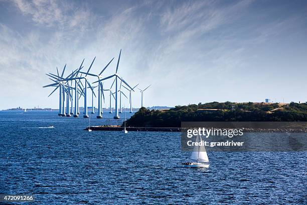 cluster di oceano vento turbine con barca a vela in primo piano - danimarca foto e immagini stock