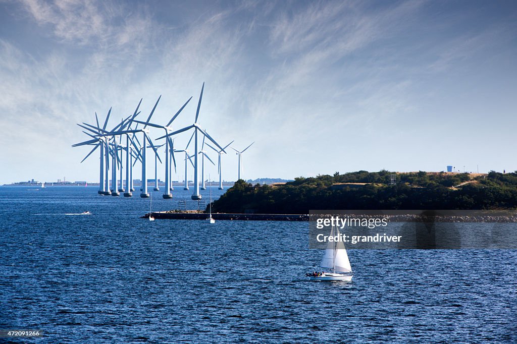 Cluster of Ocean Wind Turbines with Sailboat in Foreground