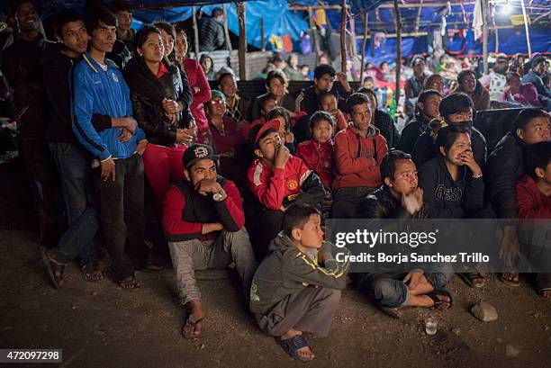 Nepali victims of the earthquake watch a movie projected onto a screen hanging from a truck on May 1, 2015 in Kathmandu, Nepal. The road from...