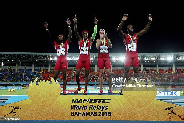 David Verburg, Tony McQuay, Jeremy Wariner, and LaShawn Merritt of the United States celebrate on the podium after winning the final of the mens 4 x...