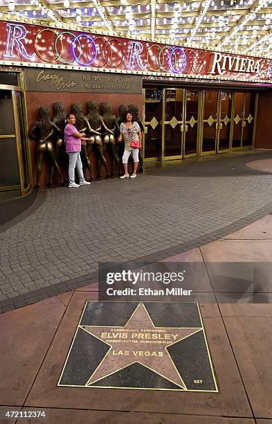 People take photos at the "Crazy Girls" bronze sculpture near Elvis Presley's star from the Las Vegas Walk of Stars at the Riviera Hotel & Casino on...