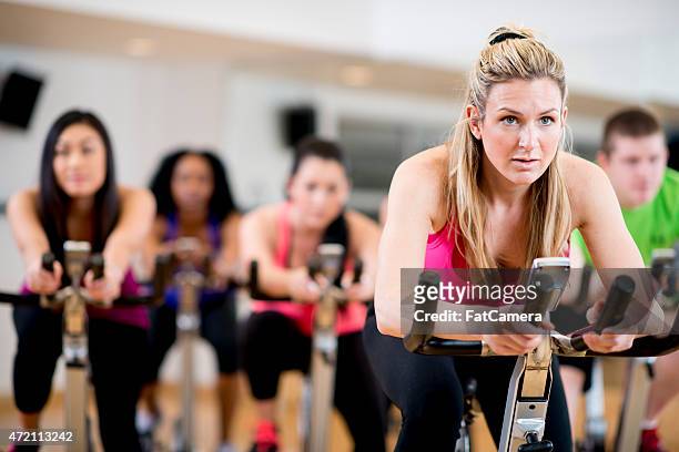 exercise bicycle class - stationary cycling class stock pictures, royalty-free photos & images