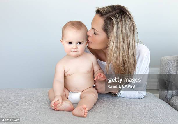 mother kissing her baby boy - beautiful blonde babes stock pictures, royalty-free photos & images