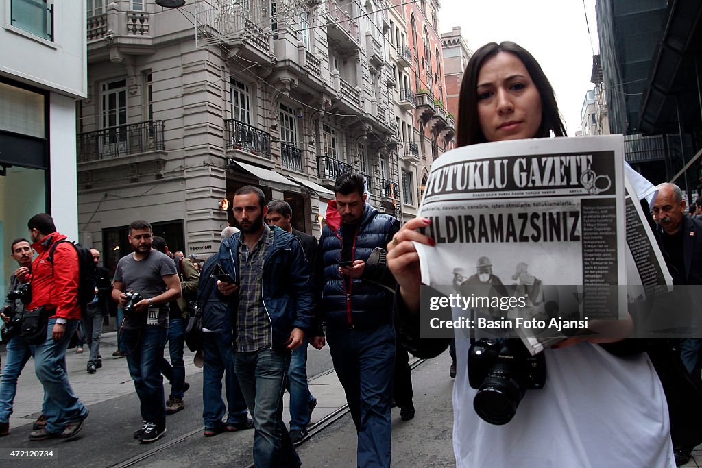 A women journalist holding a newspaper, which is called...
