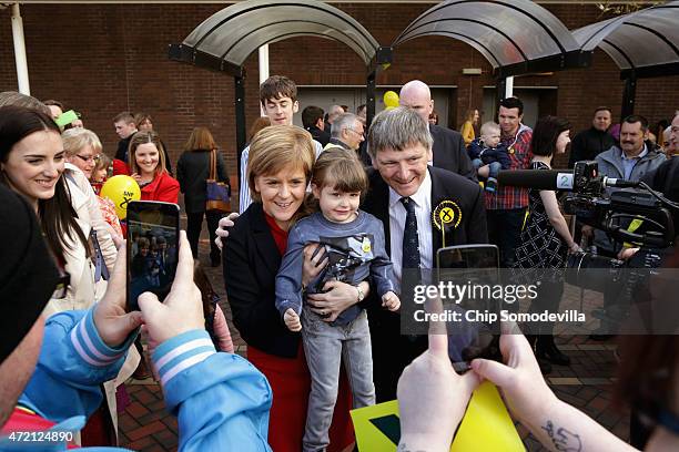 First Minister and leader of the Scottish National Party Nicola Sturgeon and SNP candidate Peter Grant pose for photographs with supporters outside a...