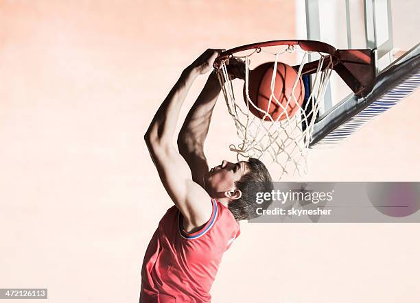 basketball spieler slam dunks. den ball. - dukning stock-fotos und bilder