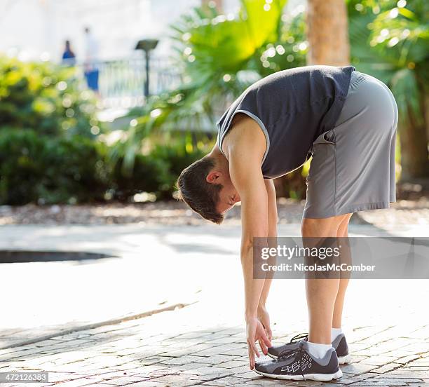 american jogger stretching in a park - toe stock pictures, royalty-free photos & images