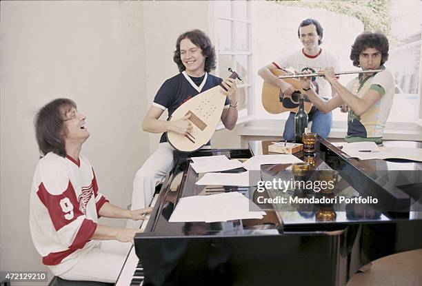 "Italian band Pooh smiling in a room while playing many music instruments. From the left: Roby Facchinetti at the grand piano; Red Canzian at the...