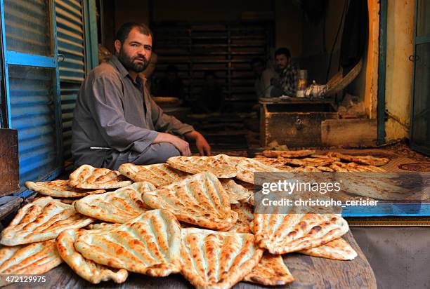 baker in kabul's market, afghanistan - afghanistan kabul bread sellers stock pictures, royalty-free photos & images