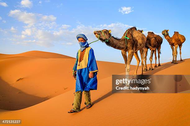 young tuareg with camels on western sahara desert in africa - toeareg stockfoto's en -beelden