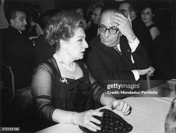 "Italian publisher Arnoldo Mondadori sitting at the table with Italian actress Andreina Pagnani . They attended the Cassaforte d'Oro awarding...