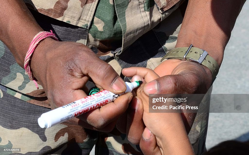 Kathmandu, Nepal: An armymen mark fingers of peoples before...