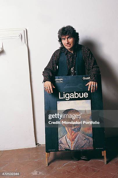 "Italian singer-songwriter Luciano Ligabue posing resting his arms on the advertising poster dedicated to the painter Ligabue in a photocall shooted...