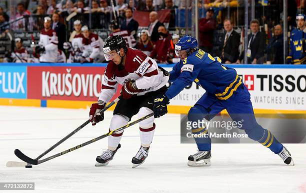 Roberts Bukarts of Latvia and John Klingberg of Sweden battle for the puck during the IIHF World Championship group A match between Latvia and Sweden...