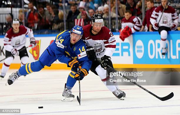 Armands Berzins of Latvia and Mattias Ekholm of Sweden battle for the puck during the IIHF World Championship group A match between Latvia and Sweden...