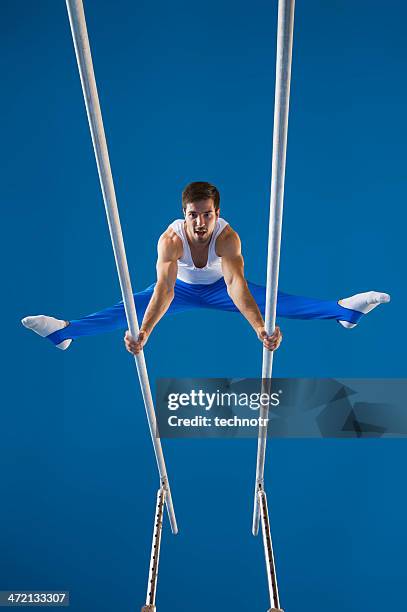 masculino ginasta executar a rotina nas barras paralelas - barras paralelas barra de ginástica - fotografias e filmes do acervo